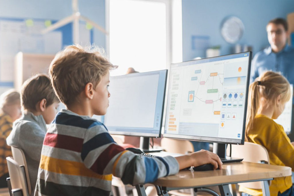 Junge Schüler haben digitalen Unterricht am Computer