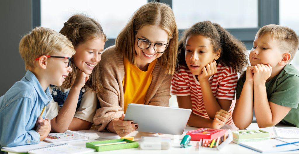 Lehrerin mit mehreren Kindern während eines Seminars zur Lehrerfortbildung